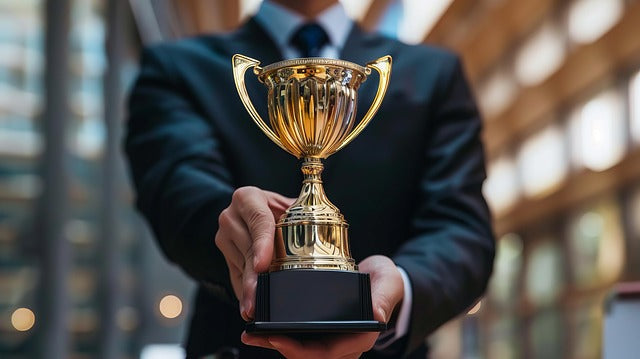 Man holding a gold trophy.